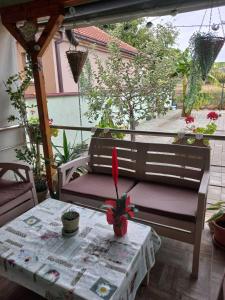 a table and a bench sitting on a porch with a table and a tableablish at The Little Green House in Petrovec +18 photos