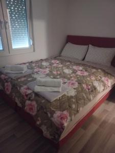 a large bed with flowers on it in a bedroom at The Little Green House in Petrovec