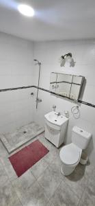 a white bathroom with a toilet and a sink at Lo de Nilda in Playa Unión