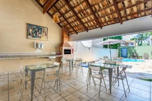 a dining room with tables and chairs and a patio at CasinhaPiri in Pirenópolis