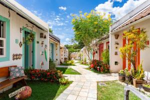 a walkway between two buildings with flowers at CasinhaPiri in Pirenópolis
