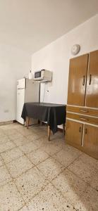 a kitchen with a table with a microwave and a refrigerator at Lo de Nilda in Playa Unión +2 photos