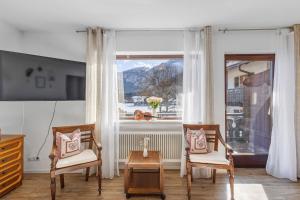 a living room with two chairs and a window at Gaestehaus Florian - Ferienwohnungen in Grainau