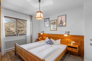a bedroom with a large bed and a window at Gaestehaus Florian - Ferienwohnungen in Grainau +10 photos