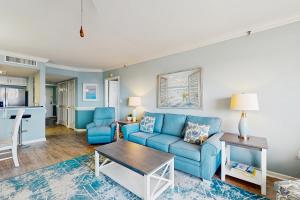 a living room with a blue couch and a table at OIB74 Kat Cove 2 in Ocean Isle Beach