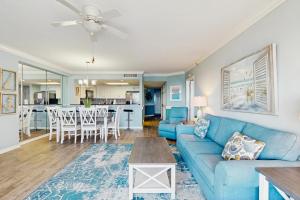 a living room with a blue couch and a table at OIB74 Kat Cove 2 in Ocean Isle Beach