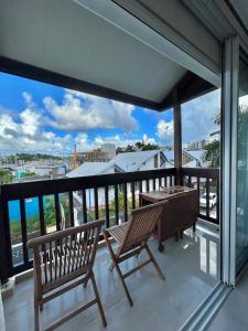 a balcony with two benches and a table on it at Vue mer sur la Marina, Le Juliana in Pointe-à-Pitre