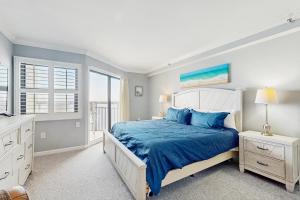 a bedroom with a bed with blue sheets and a window at OIB74 Kat Cove 2 in Ocean Isle Beach +18 photos