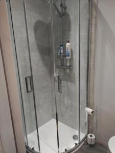a shower with a glass door in a bathroom at Rooms by the Lade Braes & Doocot in St Andrews in St. Andrews