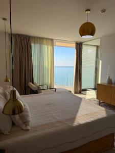 a bedroom with a large bed with a view of the ocean at Sky rooftop luxury suites in Durrës +71 photos