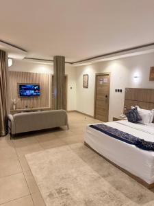 a large bedroom with a large bed and a couch at SAAFI Boutique Hotel in Abuja