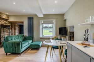 a living room with a green couch and a table at 1 Bed in Tebay oc-m29886 in Tebay
