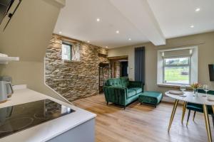 a living room with a green chair and a table at 1 Bed in Tebay oc-m29886 in Tebay