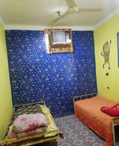 a bedroom with a blue wall with stars at Mostafa Gest House in Asyut