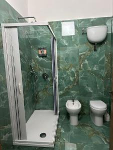 a bathroom with a shower and a toilet and a sink at Binario104 in Naples