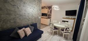 a living room with a blue couch and a table at Apartament Nowe Maniowy in Maniowy