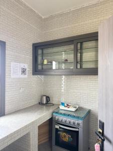 a kitchen with a stove and a counter top at Résidence NDAR CHAMBRES in Saint-Louis