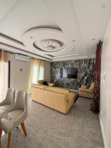 a living room with a couch and a tv at Résidence NDAR CHAMBRES in Saint-Louis