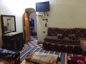 a living room with a couch and a mirror at Mostafa Gest House in Asyut