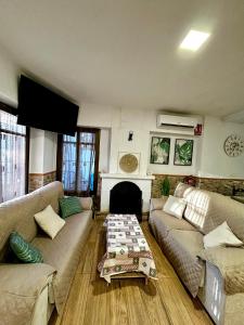 a living room with two couches and a fireplace at Casa Rural Abuelo Raimundo in Ossa de Montiel