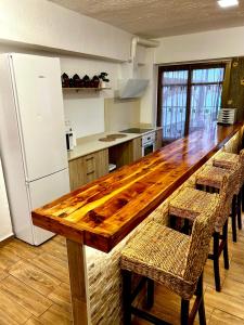 a kitchen with a wooden table and chairs and a refrigerator at Casa Rural Abuelo Raimundo in Ossa de Montiel