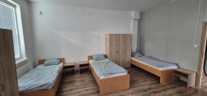 a room with three beds and a window at turistická ubytovňa LIENKA in Holíč