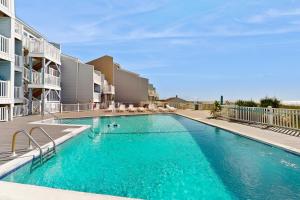 a swimming pool with blue water in a building at OIB88 PierSide Paradise in Ocean Isle Beach