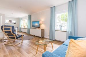 a living room with a blue couch and a table at Ferienhaus Ankerplatz in Timmendorfer Strand