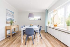 a dining room with a white table and chairs at Ferienhaus Ankerplatz in Timmendorfer Strand