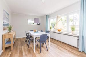 a dining room with a white table and chairs at Ferienhaus Ankerplatz in Timmendorfer Strand