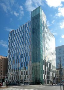 a tall glass building on a city street at Hotel Gracery Sapporo in Sapporo