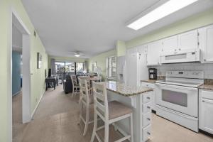 a kitchen with white cabinets and a table with chairs at OIB90 Endless Summer in Ocean Isle Beach