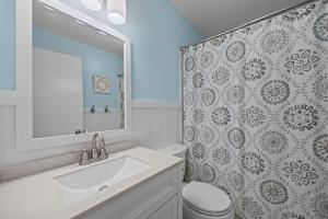 a bathroom with a sink and a toilet and a mirror at OIB90 Endless Summer in Ocean Isle Beach +30 photos