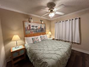 a bedroom with a bed and a ceiling fan at Sea Vista Motel in New Smyrna Beach