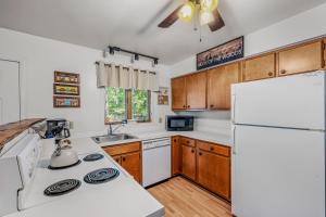 a kitchen with white appliances and a white refrigerator at Chesnutt Cabin - Riverfront, Fire Pit, Game Room, Wifi, Screen Porch, View, King Bed in Morton Grove