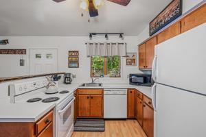 a kitchen with white appliances and wooden cabinets at Chesnutt Cabin - Riverfront, Fire Pit, Game Room, Wifi, Screen Porch, View, King Bed in Morton Grove +119 photos