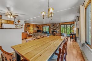 a large dining room with a large wooden table at Chesnutt Cabin - Riverfront, Fire Pit, Game Room, Wifi, Screen Porch, View, King Bed in Morton Grove