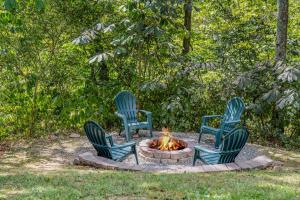 three blue chairs sitting around a fire pit at Chesnutt Cabin - Riverfront, Fire Pit, Game Room, Wifi, Screen Porch, View, King Bed in Morton Grove