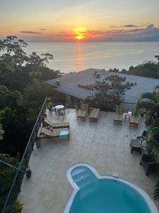 a view of a patio with a pool and a sunset at Sunshine Sanctuary Boutique Jungle Lodge in Montezuma