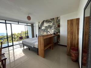 a bedroom with a bed and a large window at Sunshine Sanctuary Boutique Jungle Lodge in Montezuma