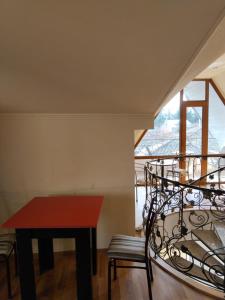 a room with a red table and chairs and a window at Vanilla Mountains in Kutaisi