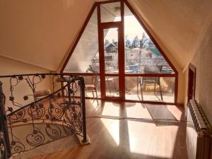 a spiral staircase in a room with a large window at Vanilla Mountains in Kutaisi