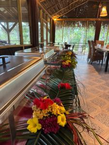 a restaurant with several tables with flowers on them at Pine Ridge Lodge Belize in San Ignacio