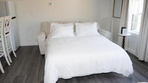 a white bed with white sheets and pillows in a bedroom at Peace Barn Getaway in Carrollton