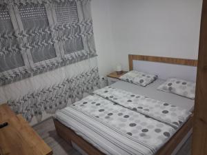 a bedroom with a bed and two pillows at Jagoda stan na dan in Prijedor