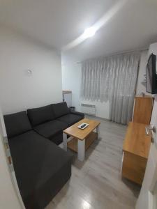 a living room with a black couch and a table at Jagoda stan na dan in Prijedor