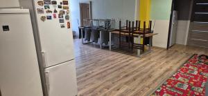 a kitchen with a refrigerator and a row of chairs at turistická ubytovňa LIENKA in Holíč