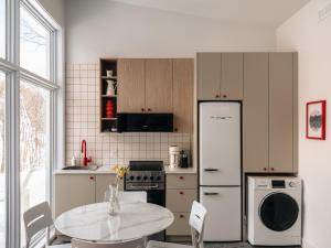 a kitchen with a table and a refrigerator at The Lofti in Sainte Béatrix +35 photos