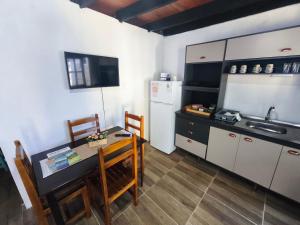 a small kitchen with a table and a refrigerator at Luz del Alba in Durazno