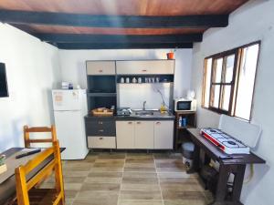 a small kitchen with a sink and a refrigerator at Luz del Alba in Durazno +8 photos